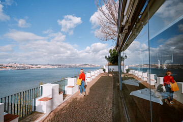 Wall Mural - Travel by Portugal. Woman enjoying view of river Tagus.