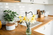daffodils bouquet in vase on the table white kitchen view