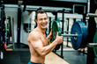 © Katja Velmans/Westend61 - Cheerful shirtless athlete holding weights disc in gym