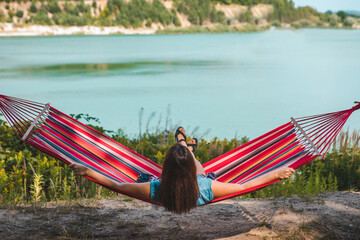Wall Mural - woman laying on hammock enjoying the view of summer lake