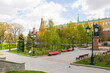 view of the Alexander Garden with its beautiful green trees and red brick Kremlin wall on a cloudy spring day and space to copy. Concept-a famous place in Moscow Russia