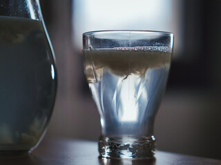 Poster - Glass full of lemonade on a table in front of the window