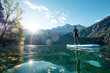 © Wilfried Feder/Westend61 - Germany, Bavaria, Garmisch Partenkirchen, Young woman stand up paddling on Lake Eibsee