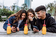 © Xavier Lorenzo/Westend61 - Cheerful female friends with young man using smart phone