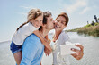 © Roger Richter/Westend61 - Cheerful family taking selfie through mobile phone by lake