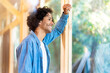 © steve brookland/Westend61 - Young man smiling while leaning on glass window at front yard