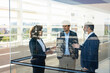 © steve brookland/Westend61 - Male and female entrepreneur having discussion while standing in modern office