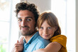 © steve brookland/Westend61 - Smiling redhead daughter with blue eyes cuddling father in living room