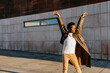 © Tania Cervi√°n/Westend61 - Man dancing with arms raised against building during sunset
