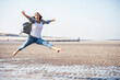 © Uwe Umst√§tter/Westend61 - Cheerful young woman jumping over wet sand on sunny day