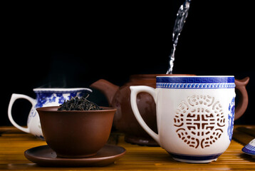 Wall Mural - Chinese tea ceremony. Famous chinese red tea Lapsang souchong in a ceramic tea pot and cup on a bamboo tea desk.