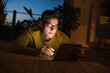 © Uwe Umst√§tter/Westend61 - Young man in eyeglasses using digital tablet while lying on carpet in living room during night