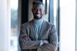 © JOSEP SURIA/Westend61 - Smiling businessman standing with arms crossed in office