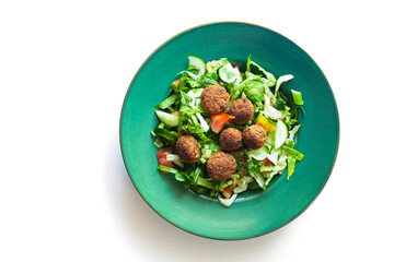 Green vegan salad from green leaves mix and vegetables. Top view on white table.