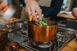 © Mareen Fischinger/Westend61 - Chef putting vegetables in copper saucepan while making Broth soup in kitchen