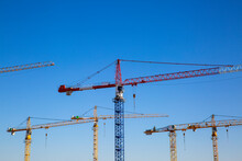 Germany, Bavaria, Munich, Construction Cranes Against Blue Sky