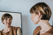 © Mareen Fischinger/Westend61 - Thoughtful woman looking at reflection in mirror