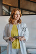 © Mareen Fischinger/Westend61 - General practitioner with digital tablet standing at clinic