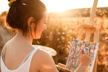 Young Woman Artist Painting On Easel