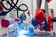 © Daniel Ingold/Westend61 - Robotic arm welding while male entrepreneurs working with laptop in factory
