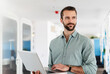 © Daniel Ingold/Westend61 - Young male professional with laptop standing at office