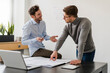© Daniel Ingold/Westend61 - Male entrepreneur discussing with colleague over blueprint at office