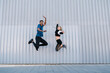 © Ezequiel Gim√©nez/Westend61 - Carefree male and female friends jumping high by wall