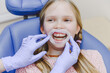 © Ekaterina Yakunina/Westend61 - Portrait of little girl wearing dental gag lying in dentists chair during exam