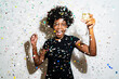 © Giorgio Fochesato/Westend61 - Happy woman with champagne flute dancing while standing amidst confetti against white background