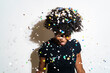 © Giorgio Fochesato/Westend61 - Smiling woman with confetti falling on head standing against white background
