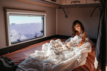 Portrait Of Little Girl Lying In Bed Inside Motor Home