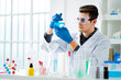 © Giorgio Fochesato/Westend61 - Young scientist measuring chemical in flask at laboratory