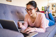 © Giorgio Fochesato/Westend61 - Young woman with credit card smiling while using laptop at home