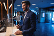 © Dusan Petkovic - Happy attractive businessman standing at a reception in the luxury hotel and checking in. Travel destinations, love my job, business trip