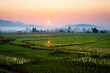 © Tandem Stock - The sun sets behind foggy hills and expansive rice paddy fields near Chiang Mai, Thailand