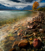 Autumn Landscape Of A Body Of Water With Snow Covered Mountains, USA.