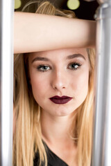 Poster - Blonde attractive female in a black dress posing near railings