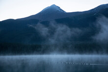 A Flock Of Canada Geese Cross Maligne Lake At Sunrise. Jasper National Park, Canada.