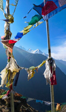 Tibetan prayer flags flutter in the wind below high Himalayan peaks.