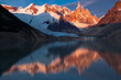 © Tandem Stock - Golden mountain peak and light up with first light upon Cerro Torre and reflect in the lake below in Patagonia, Argentina.