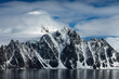 © Tandem Stock - Ice capped mountains rise up out of the sea in Antarctica.