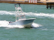 Blue and white fishing boat powered by three outboard engines.