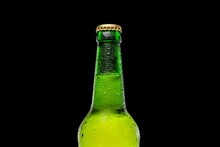 Green Beer Bottle On Black Background. Cold And Refreshing Beer