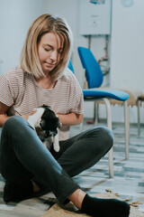 Poster - Vertical shot of a young caucasian female posing with her cute black and white cat