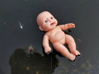 Wall Mural - Baby doll floating on water close up 