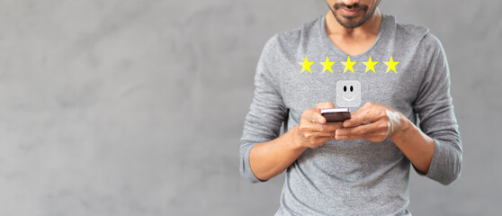 Customer pressing on smartphone with five star icon for feedback review satisfaction service