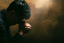 Religious Man Praying To God Resting His Chin On His Hands.His Hands Are Praying For God's Blessings.