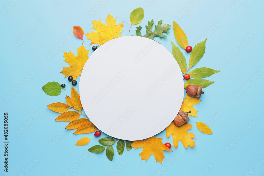 Blank card and autumn leaves on color background