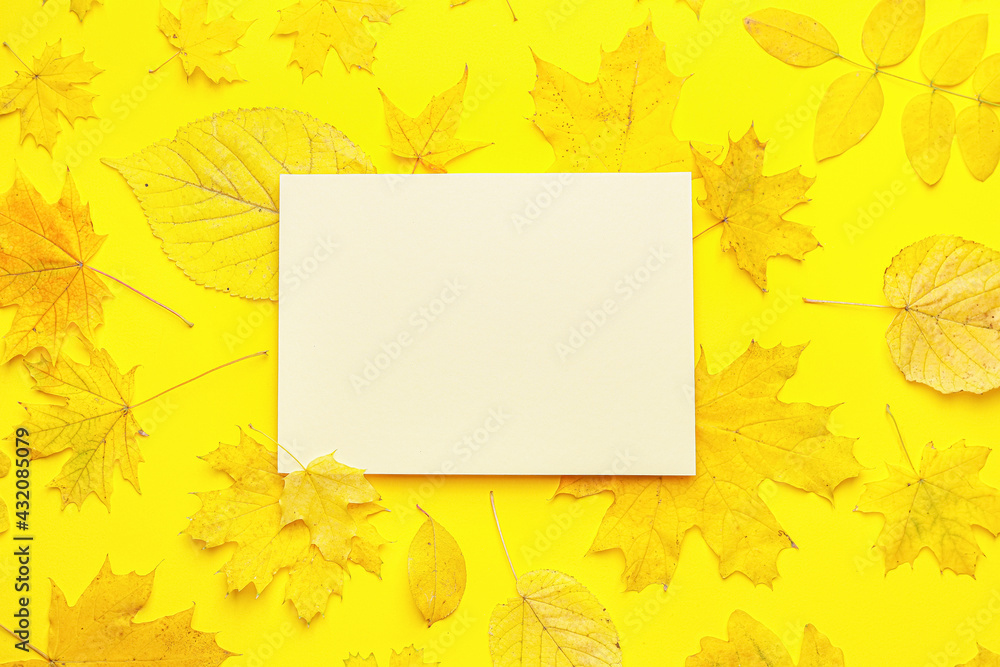 Blank card and autumn leaves on color background