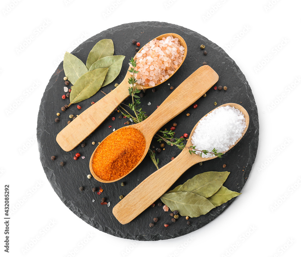 Spoons with different salt and spices on white background